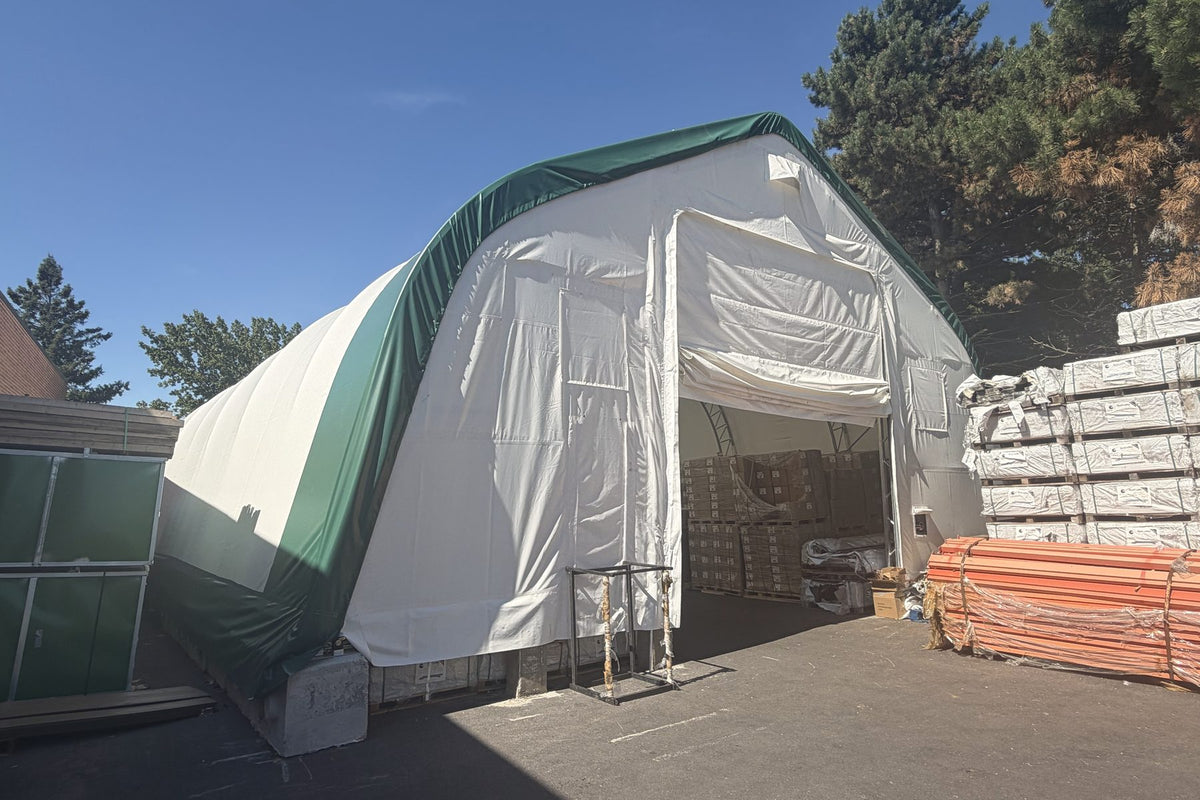 Double-truss fabric storage shelter in use for outdoor equipment storage